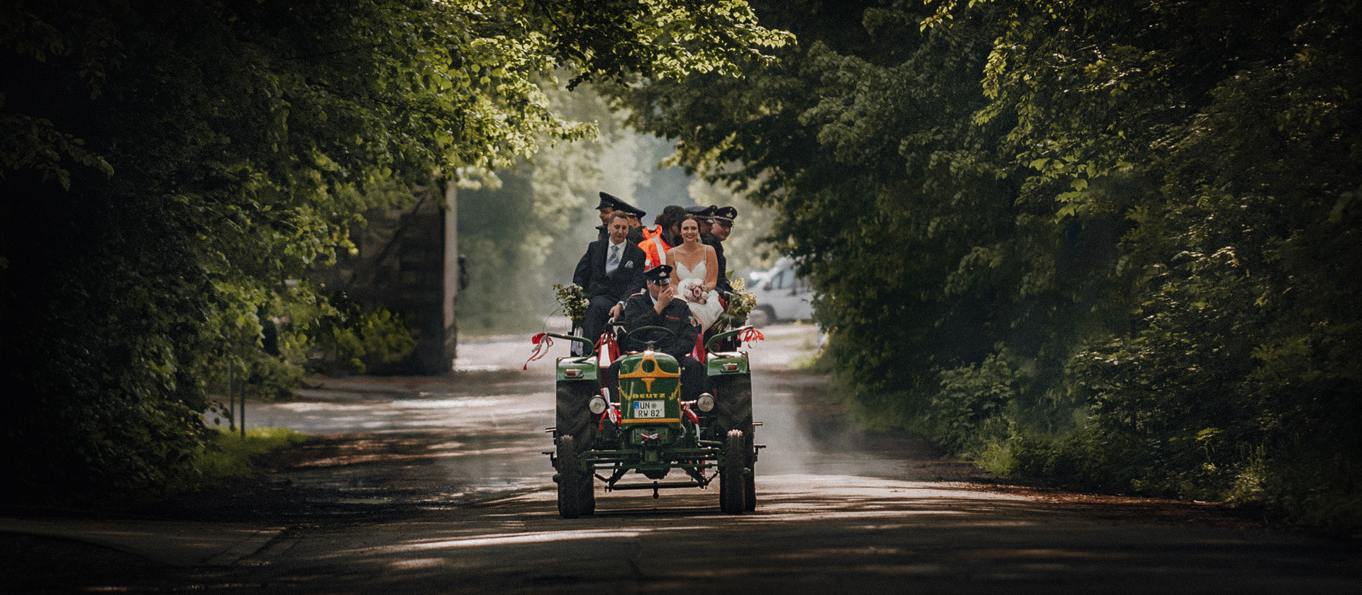 Brautpaar fährt mit Trecker